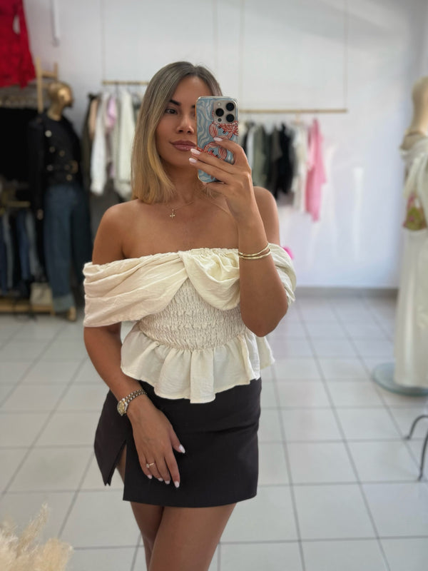 Elegantni ženski top u bež boji savršen je izbor za ženstvene i moderne kombinacije.