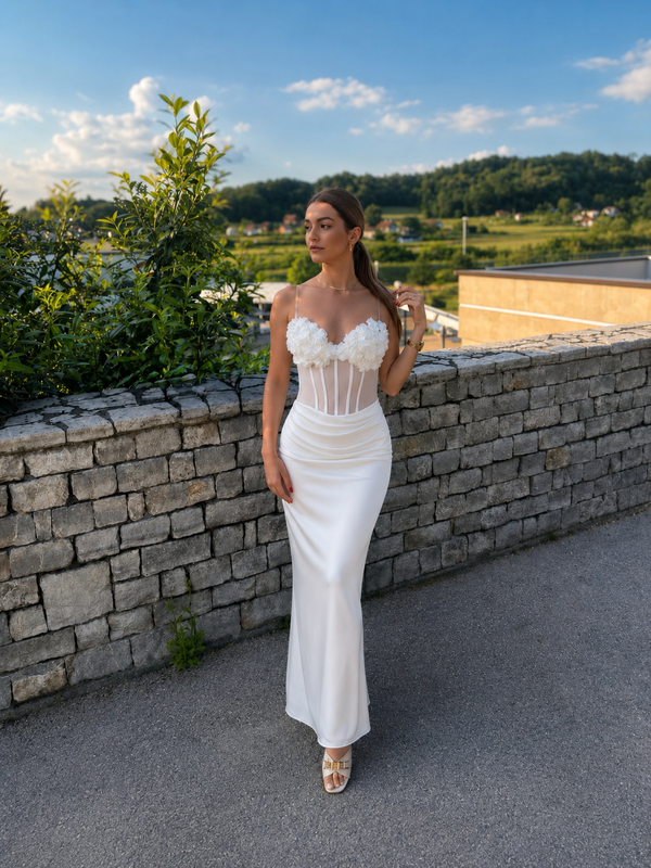 Elegantna bijela maxi haljina s korzetom i cvjetnim detaljima.